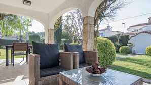 An outdoor patio area with wicker furniture, a glass-top table, and a bowl of fruit. - Th11 Villa in Cambrils con Piscina (Cambrils)