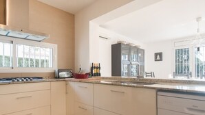 A modern kitchen with a built-in dishwasher, a toaster, and a wine rack. - Th11 Villa in Cambrils con Piscina (Cambrils)