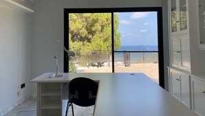 A modern room with a large window, a desk, and a chair.