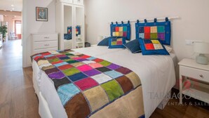 Un dormitorio con una cama grande, un aparador, un armario y una mesita de noche.