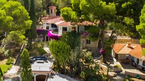 A villa with a red-tiled roof, surrounded by lush greenery and trees. - Th06 Villa in Miami Platja 6 Bedrooms (Mont-roig del Camp)