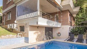 A residential building with a swimming pool, a balcony, and a garden area.