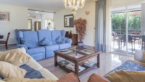 A living room with a blue sofa, a coffee table, and a chandelier.