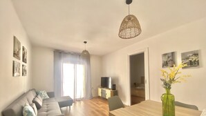 Un salon moderne avec un canapé, une table à manger et un téléviseur.