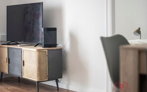 A modern room with a grey cabinet, a television, and a small speaker. - Th16 Arc de Sant Llorens (Tarragona)