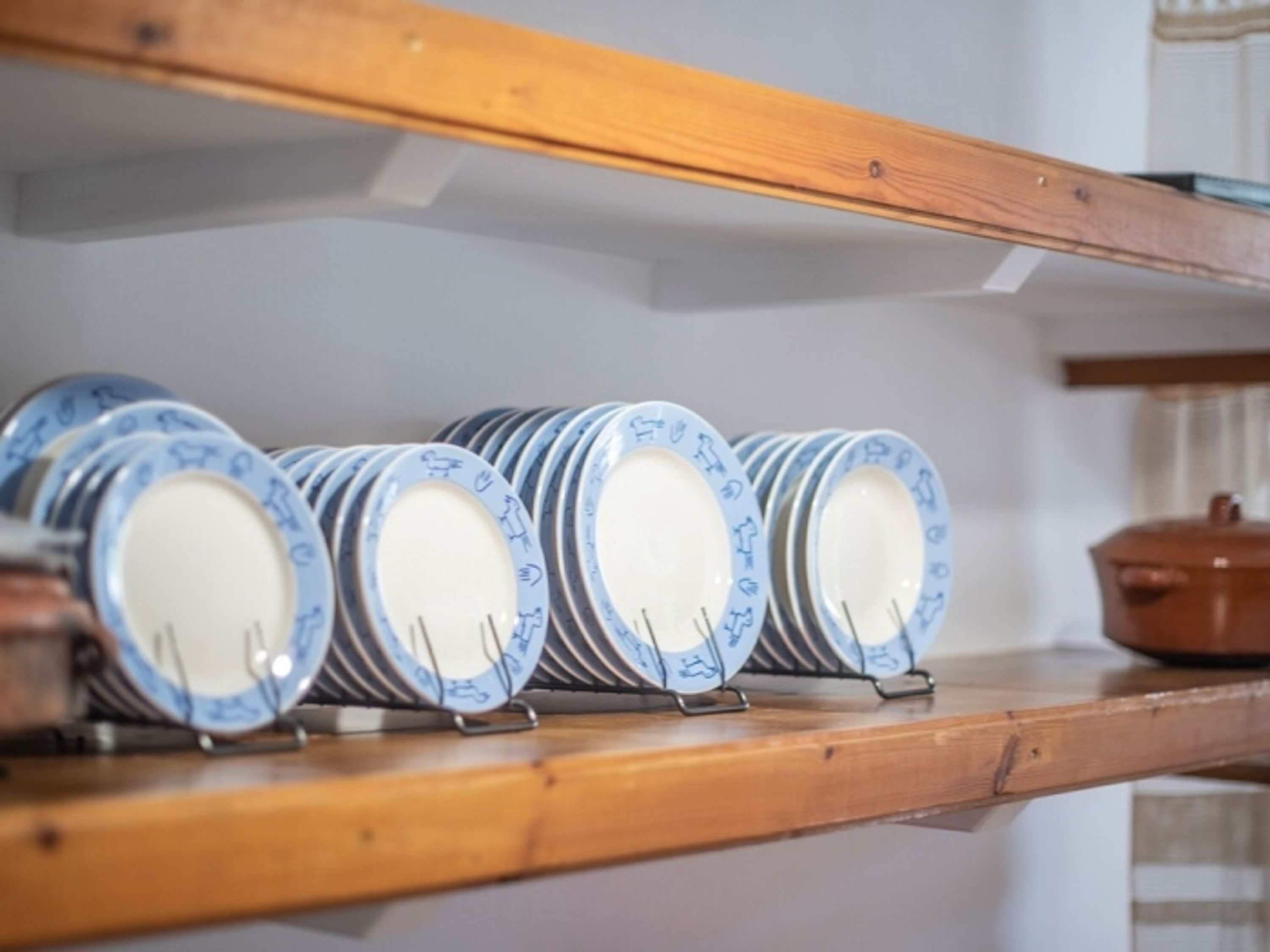 A shelf with neatly stacked plates.