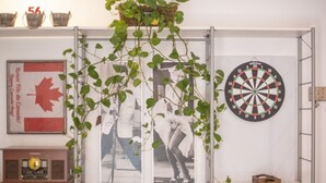 A room with a dartboard, a framed picture, a radio, and shelves with various items. - Th146 Apartamento Elegante Cerca de la Catedral (Tarragona)