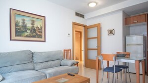 Una sala de estar con un sofá, una mesita de centro y un cuadro en la pared.