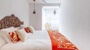 A bedroom with a bed, a ceiling fan, a window with curtains, and a chair. - Th163 Apartamento Via Augusta con Vistas al mar (Tarragona)