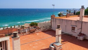 A rooftop terrace with a view of the sea, featuring a brick floor, railings, and a chimney. - Th163 Apartamento Via Augusta con Vistas al mar (Tarragona)