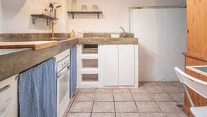 A compact kitchen with a built-in oven, a sink, and a wooden cabinet. - Th125 Atico con Vistas en Tarrgona (Tarragona)