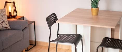 Una sala moderna con un sofá, dos sillones, una mesa, una lámpara y una planta de cactus.