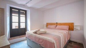 A bedroom with a bed, a window, and a door. - Th56a Apartamentos Murmur la Font (Tarragona)