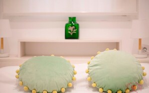 Two green pillows with yellow pom-poms on a white bed. - Th03 Apartamento Cerca de la Playa en la Pineda (Salou)
