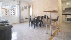 A modern apartment with a dining area, kitchen, and a view of buildings outside. - Th134 Apartamento Moderno Centro de Tarragona (Tarragona)
