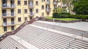 Un conjunto de escaleras exteriores con barandillas metálicas que conducen a un edificio con varios balcones.