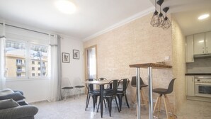 Eine moderne Wohnung mit Essbereich, Küche und Blick auf Gebäude.
