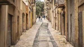 A narrow cobblestone street flanked by historic buildings with arched doorways and balconies. - Th86 Apartamento con Encanto en Parte Alta (Tarragona)