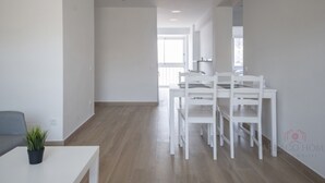 A modern, minimalist living room with a dining area. - Th64 Apartamento Moderno Cerca de la Universidad (Tarragona)