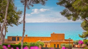 A coastal property with a view of the sea, featuring a building with a flat roof and a small balcony. - Th100 Villa en Tamarit con Vistas al mar (Tarragona)