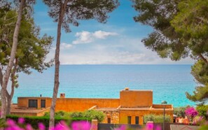 A coastal property with a view of the sea, featuring a building with a flat roof and a small balcony. - Th100 Villa en Tamarit con Vistas al mar (Tarragona)