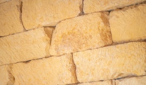 Un mur de pierre à la texture rugueuse et aux formes irrégulières.