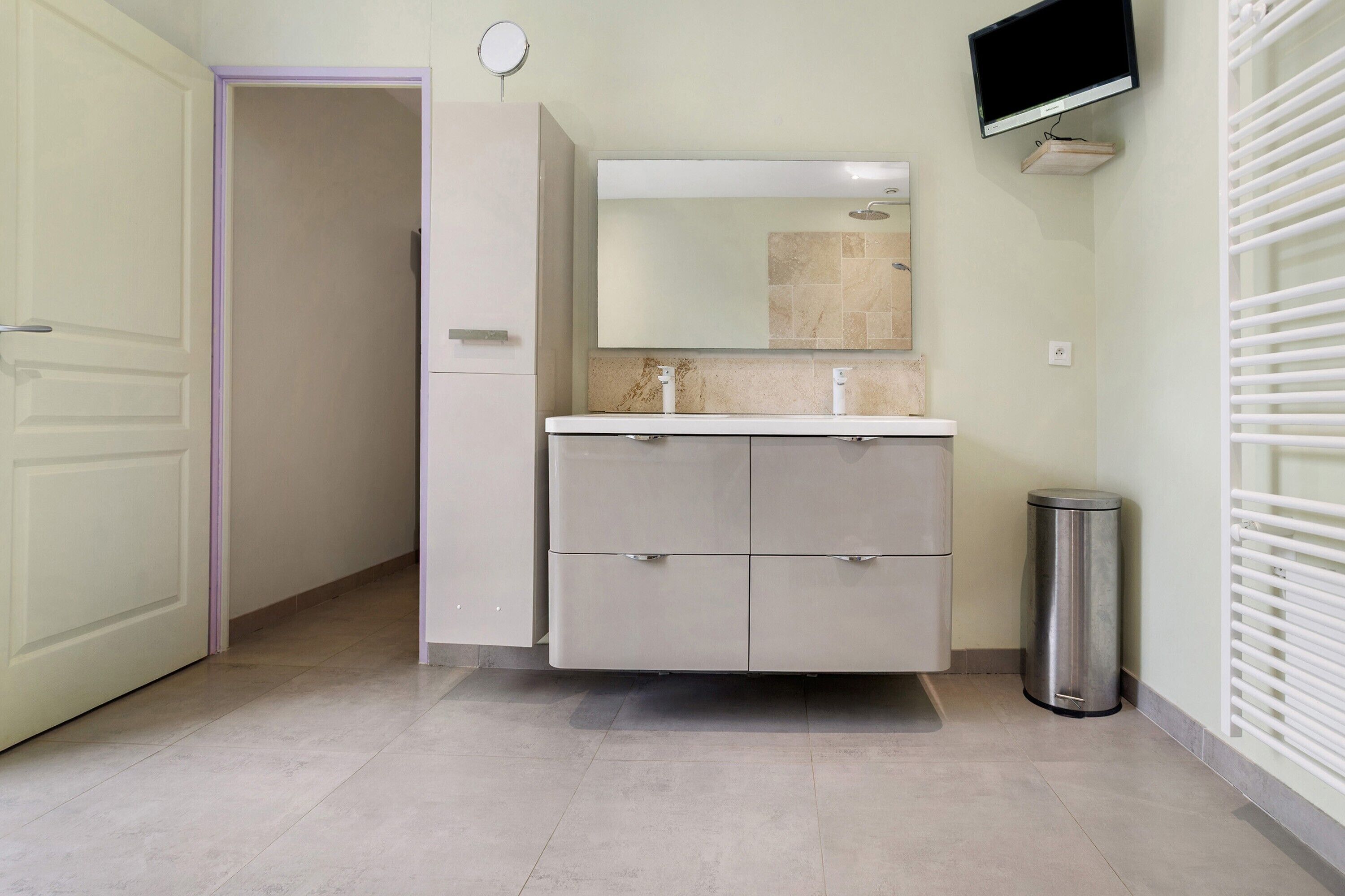 A bathroom with a vanity, mirror, sink, and toilet.