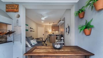 A dining area with a wooden table, chairs, and a hanging plant.