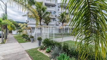 Un edificio residencial con balcones, un espacio al aire libre cubierto y jardines bien cuidados.