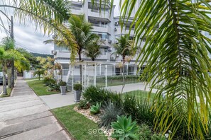 Un edificio residencial con balcones, un espacio al aire libre cubierto y jardines bien cuidados.
