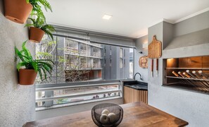 Una cocina moderna con un amplio ventanal, una mesa de comedor de madera y plantas en macetas.