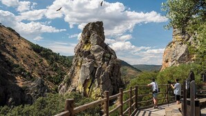 A wooden observation deck with a railing, overlooking a rocky landscape and a valley. - CASA RURAL AMANECER (Castañar de Ibor)