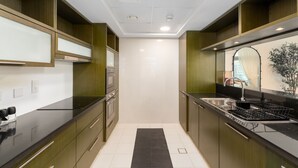 Une cuisine moderne avec des meubles en bois, un plan de travail noir et un évier en acier inoxydable.