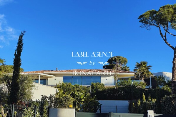 A modern building with a clear blue sky. The text "LABEL AGENCY by BONAPARTE" is visible on the facade.