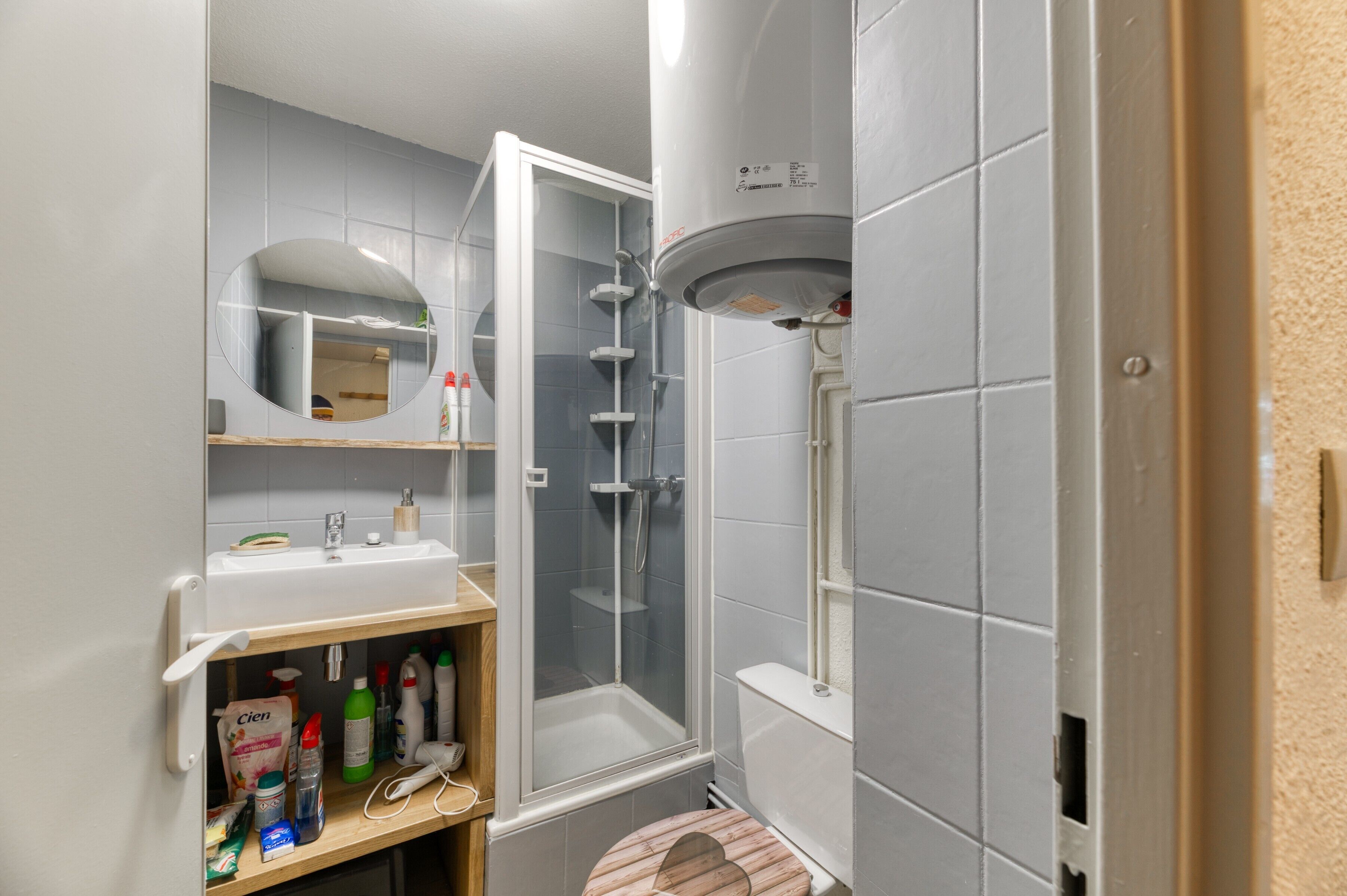 A bathroom with a shower, sink, and mirror.