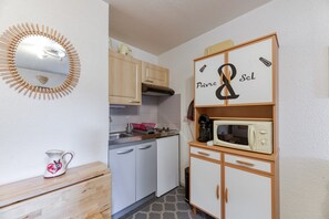 A compact kitchen with a microwave, a coffee maker, and a small refrigerator.