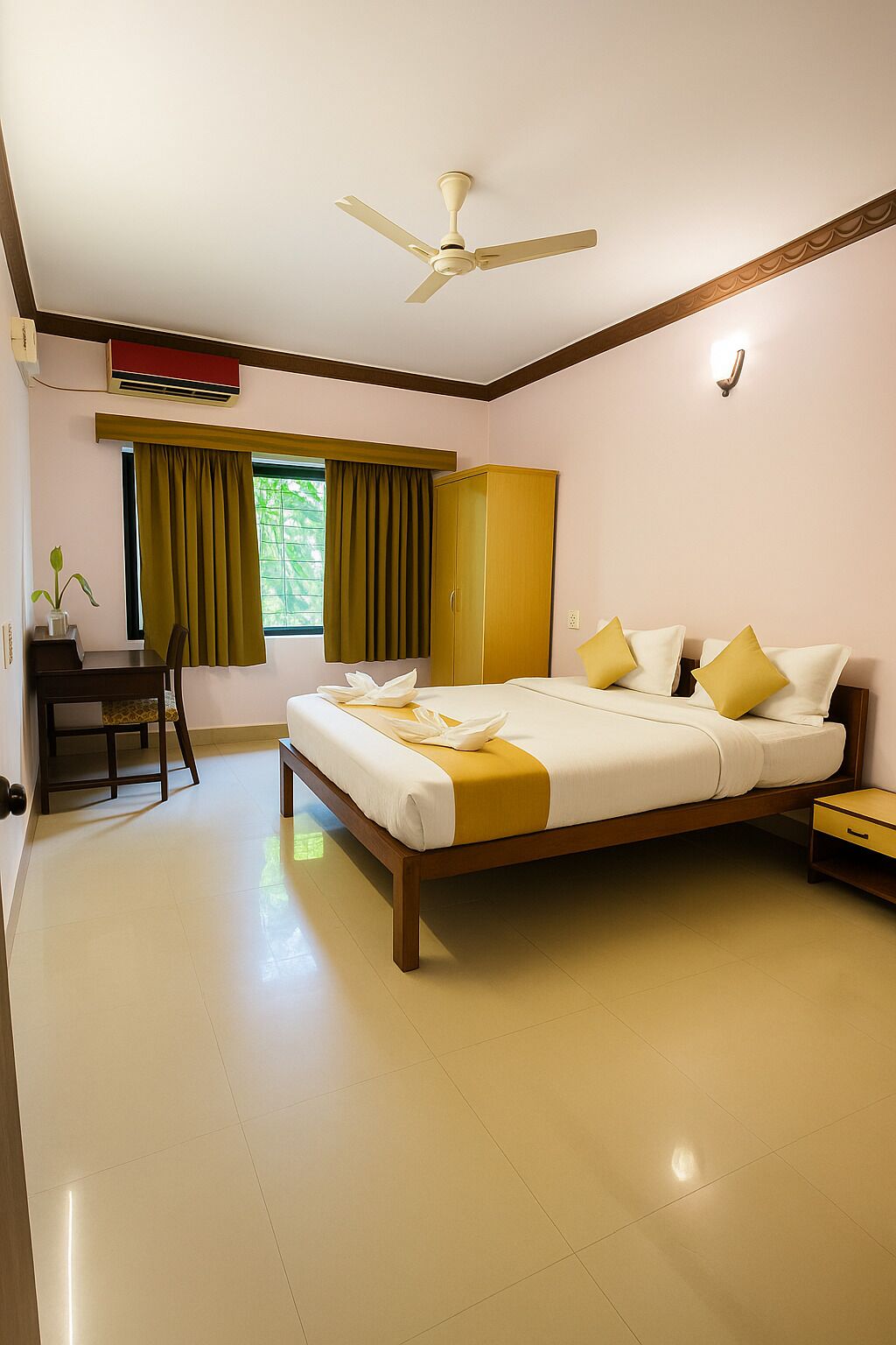 Une chambre d’hôtel équipée d’un lit, d’un bureau, d’une armoire, d’un ventilateur de plafond et d’une fenêtre avec des rideaux.