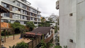 Un moderno edificio de apartamentos con varios balcones y un jardín en la azotea.