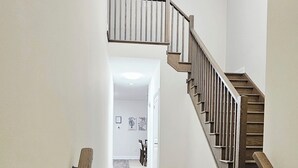 A wooden staircase with a handrail, leading to an upper floor.