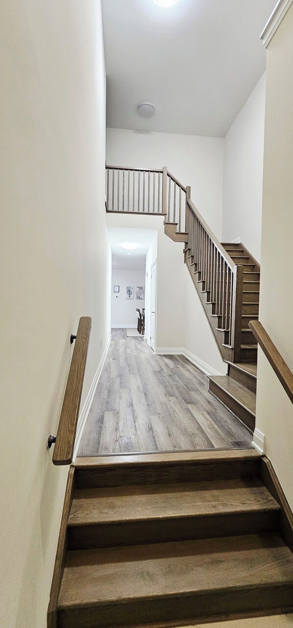 A wooden staircase with a handrail, leading to an upper floor.