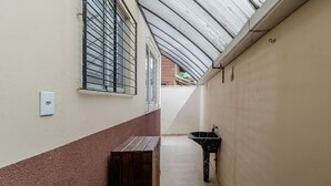 A narrow corridor with a window, a bench, and a sink. - Apt Just Minutes From Lagoa da Conceicao - Sis0005 (Florianópolis)