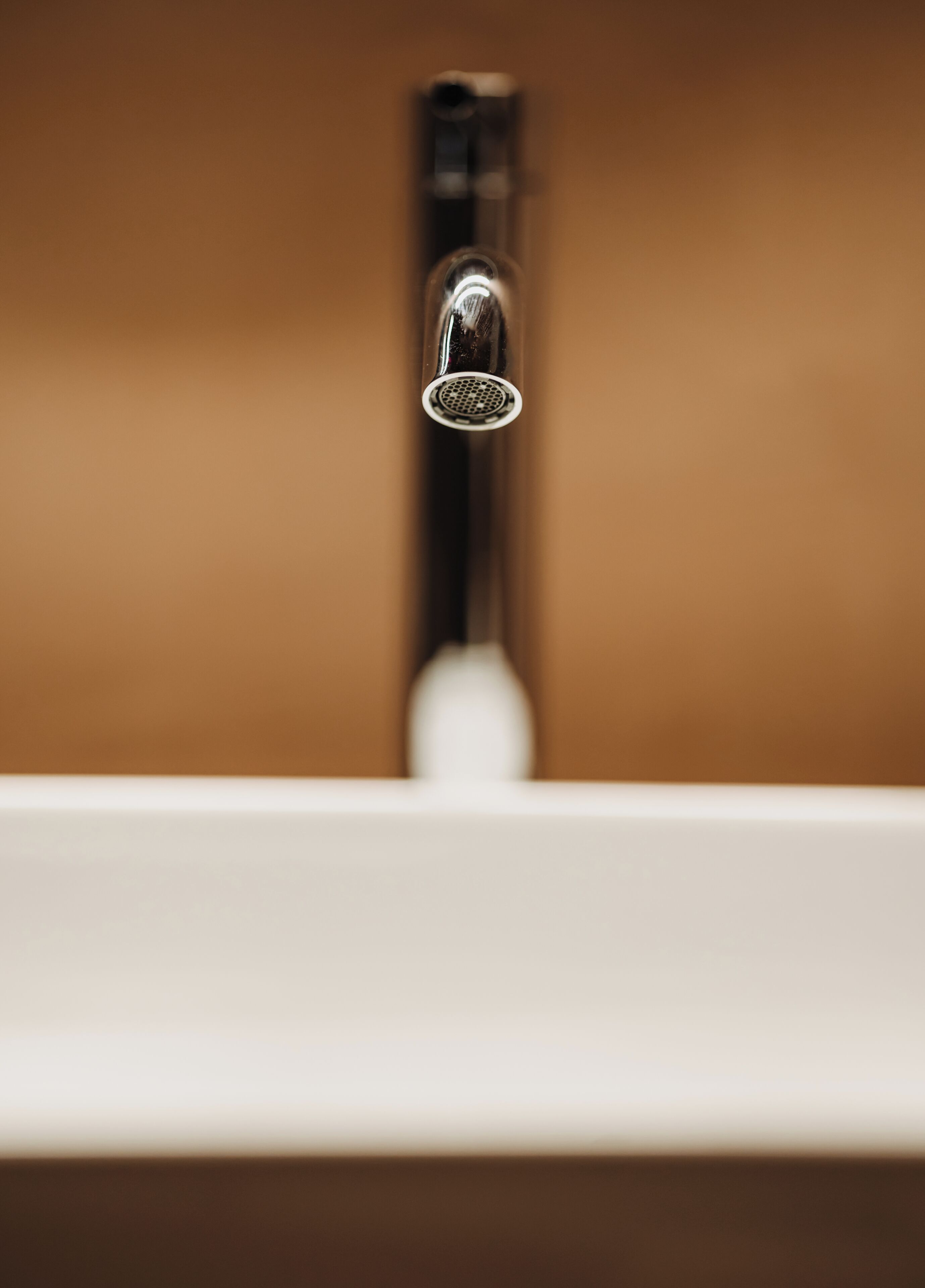 A bathroom sink with a chrome faucet and a white countertop.