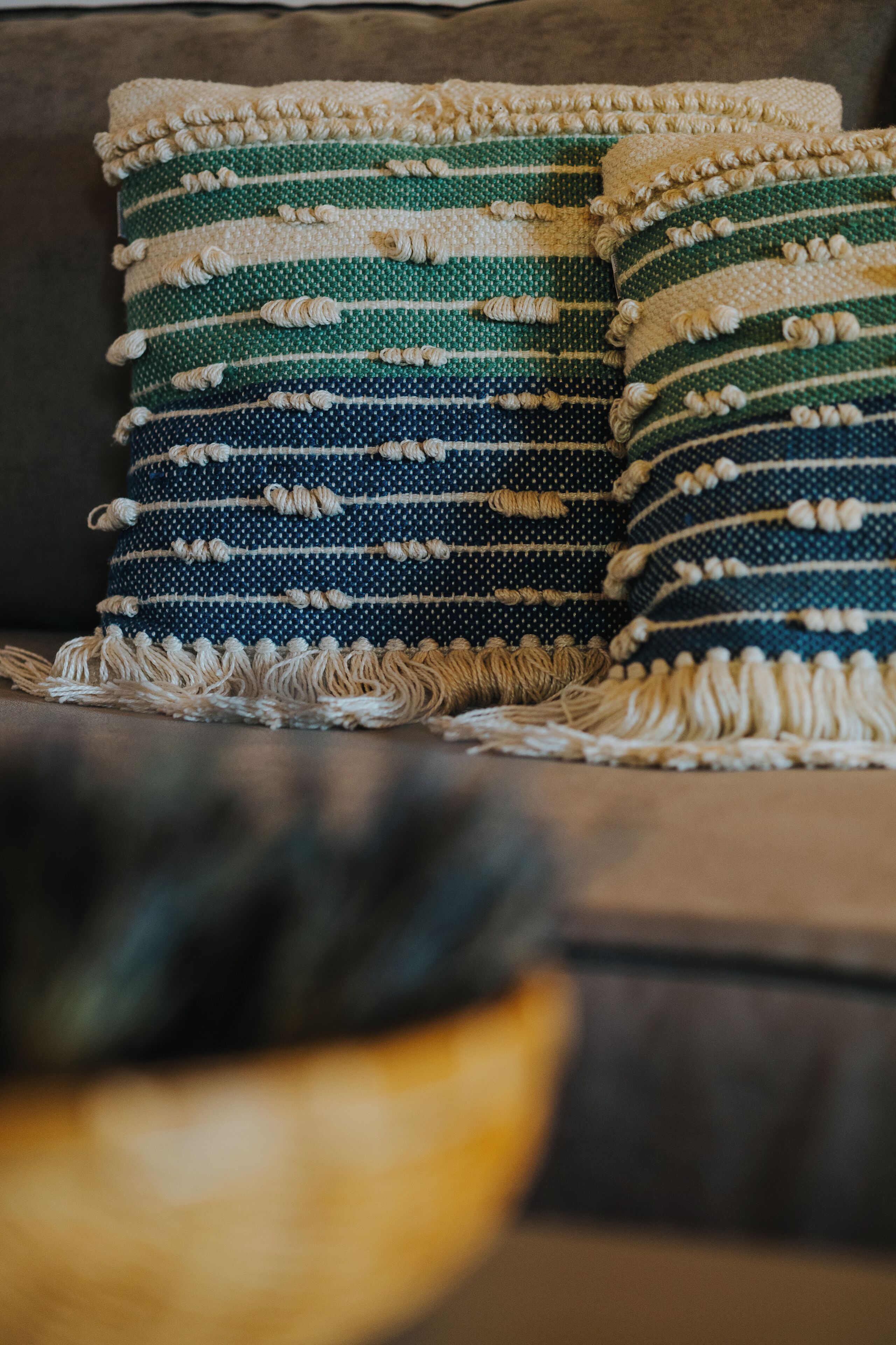 Un sofá con un plaid estampado y almohadas a juego.
