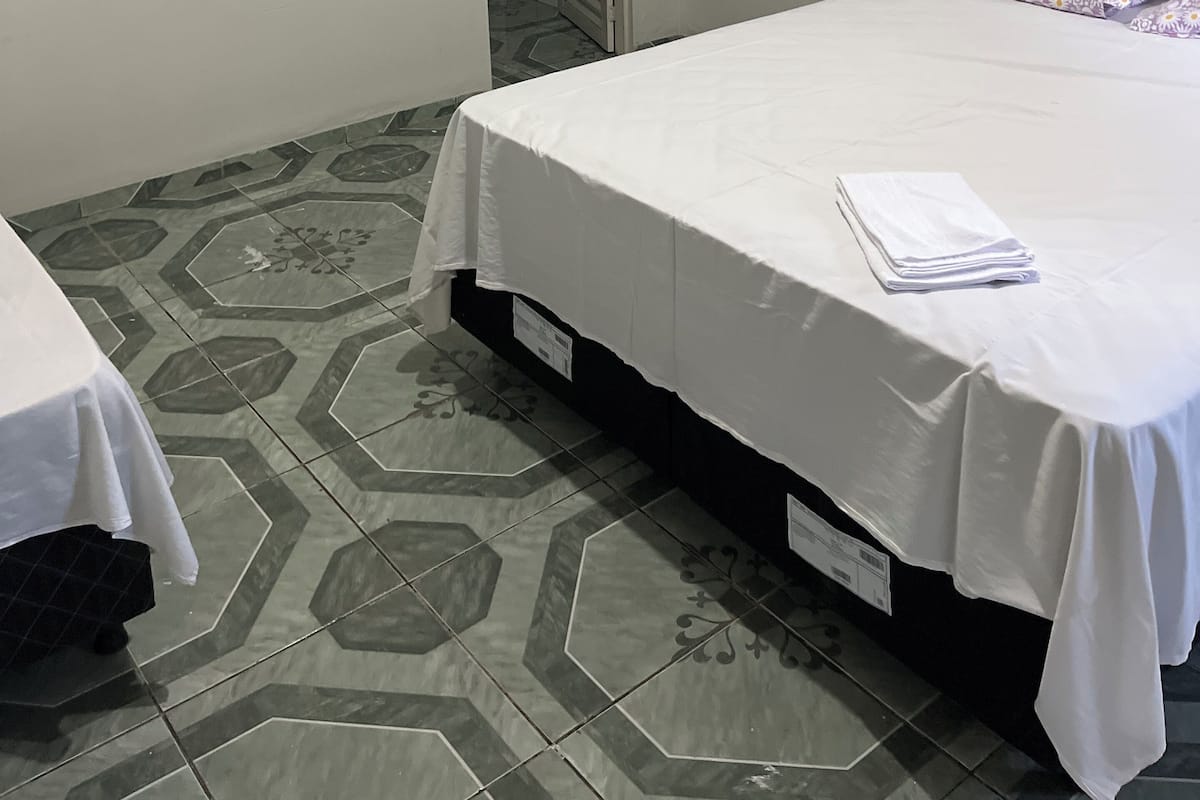 Una habitación pequeña y limpia, con una cama, una mesita de noche y un armario.