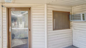 A house with a sliding glass door, a window with a mesh screen, and a garage door.