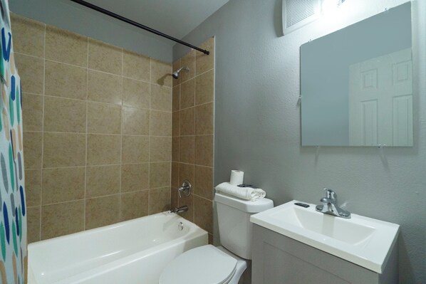 A bathroom with a bathtub, toilet, and sink. - Capital O Parker Motel Clute Jackson Tx 332 (Clute)