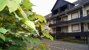 A residential building with a two-story structure, balconies, and a paved driveway. - Apartment With Covered Balcony (Winterberg)