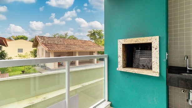 Un balcone con vista su una casa vicina e un muro in maiolica con una piccola finestra.