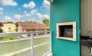 A balcony with a view of a neighboring house and a tiled wall with a small window. - Apt W/balcony and BBQ 150m From the Beach Sdp0206 (Florianópolis)