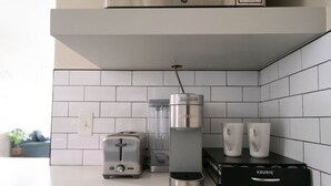 A kitchen with a toaster, a coffee maker, and a coffee pod dispenser.